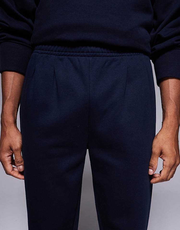https://images.asos-media.com/products/asos-design-straight-leg-joggers-with-pleats-in-navy/209009259-4?$n_750w$&wid=750&fit=constrain
