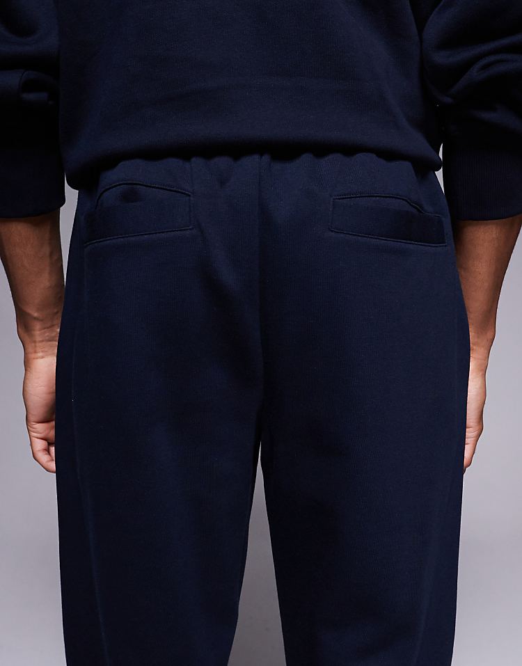 https://images.asos-media.com/products/asos-design-straight-leg-joggers-with-pleats-in-navy/209009259-5?$n_750w$&wid=750&fit=constrain