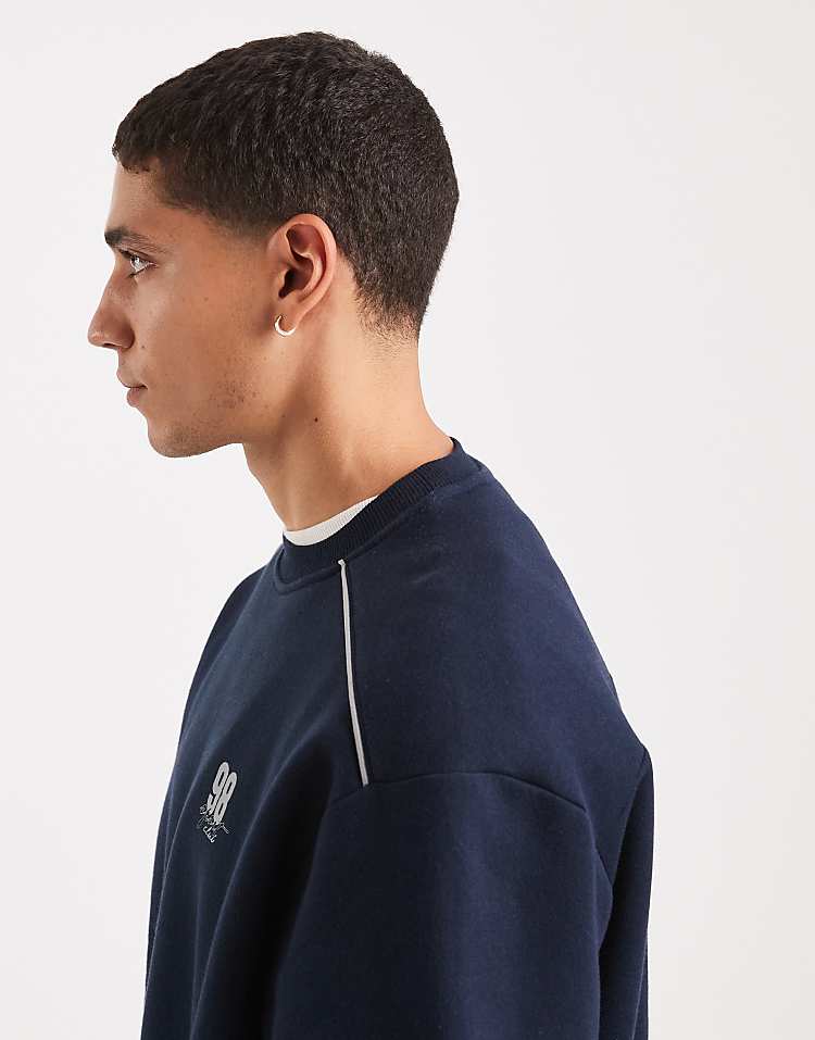 https://images.asos-media.com/products/asos-design-relaxed-fit-sweatshirt-with-piping-and-sports-number-graphic-in-navy/209669250-4?$n_750w$&wid=750&fit=constrain
